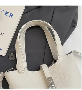 Detalle del bolso de cuero granulado blanco crema con cierre de metal plateado brillante