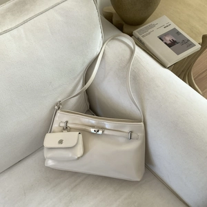 Dettaglio della borsa a spalla in pelle beige con fibbia argento e mini pochette coordinata