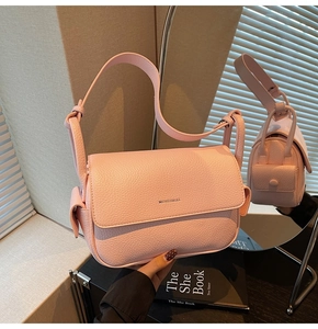 Detail of pink lychee grain leather bag showing fine stitching and brand logo