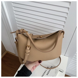 Detailed macro view of the beige lychee grain leather texture and golden metal twist lock