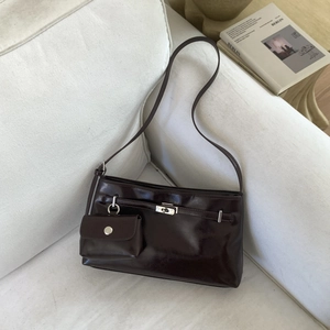 Dettaglio borsa sottobraccio marrone scuro lucida con chiusura in metallo e mini pouch