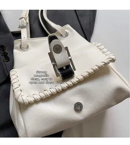 Détail du sac seau crème avec fermeture magnétique et surpiqûres tressées décoratives