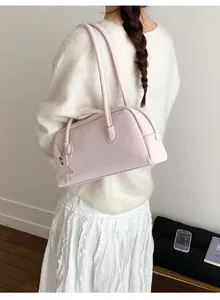 Detail view of pink rectangular shoulder bag with star charm on model's shoulder