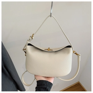 Detail of creamy white litchi grain leather handbag with vintage gold metal twist lock