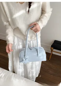 Detail of light blue bowling handbag with star charm and smooth leather texture