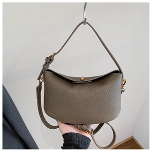 Detail of taupe lychee grain leather handbag with gold twist lock and moon shape
