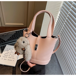 Bolso cubo de cuero rosa con grano litchi, colgante de conejo y hebilla plateada fina