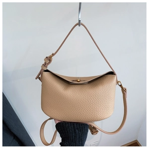 Detail showing the lychee grain texture and metal buckles of the apricot hobo handbag