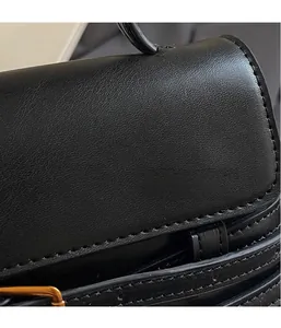 Vue détaillée du cuir noir grainé avec surpiqûres précises et finitions métalliques