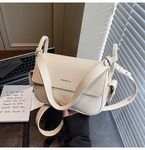 Detail shot of cream lychee texture leather crossbody bag with brand logo lettering