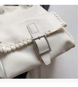 Détail du sac seau blanc avec boucle argentée et finitions de couture tissée