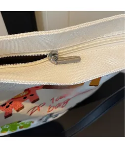 Close-up of smooth metal zipper pull and colorful horse embroidery on canvas tote bag