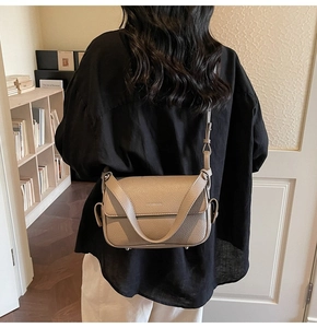 Detailed side view of beige pebble leather shoulder bag with adjustable strap and flap closure