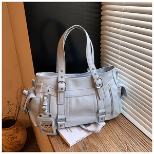 Dettaglio della borsa tote in pelle azzurra con fibbie metalliche e tasca laterale morbida