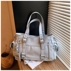 Dettaglio della borsa tote celeste in ecopelle con tasche multiple e fibbie in metallo