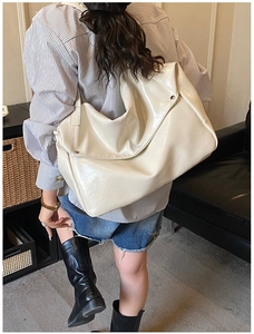 Grande borsa tote chic bianco crema vista di lato su una modella in un ambiente caldo
