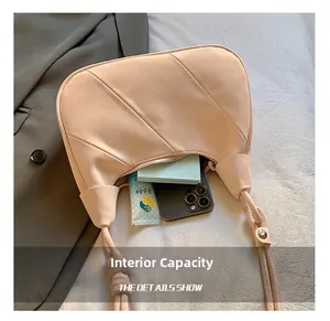 Detail view of large capacity interior showing phone and tissues in pleated shoulder bag