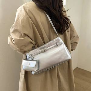 Dettaglio della borsa a spalla argento con una piccola pochette staccabile sul lato