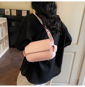 Pink lychee grain leather crossbody bag detail with side strap and metal protective feet