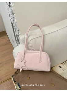 Detail of light pink baguette bag featuring a matching star charm and fine leather texture