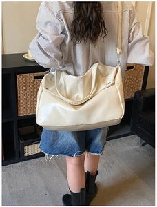 Vista dettagliata della borsa tote grande in pelle PU bianco crema portata a spalla