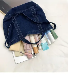 Deep blue denim tote bag interior showing large capacity with daily essentials and iPad