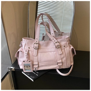 Dettaglio borsa tote in ecopelle rosa con fibbie argentate e ciondolo a forma di orso