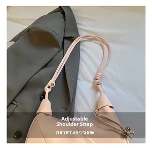 Detail showing the adjustable knotted shoulder strap of a pink minimalist hobo bag