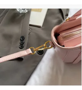 Détail du sac seau en cuir rose montrant les finitions dorées et les coutures fines