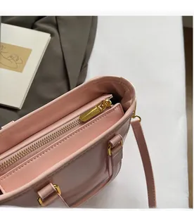 Détail de la fermeture éclair dorée fluide sur ce sac seau rose élégant pour femme