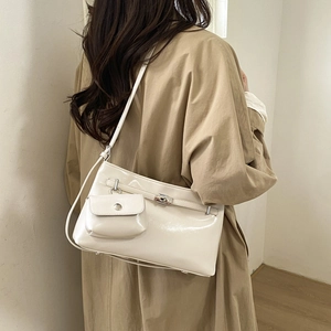 Borsa a spalla in pelle verniciata bianco crema con fibbia argento indossata da modella