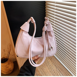 Detail of pink hobo bag featuring a knotted strap with silver metal ball accents