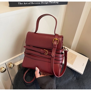 Sac à bandoulière en similicuir bordeaux avec boucles de ceinture décoratives