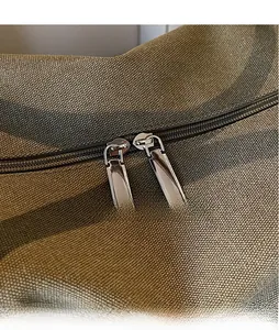 Close-up of smooth metal dual zippers on durable canvas fabric travel duffel bag