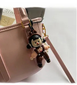 Détail du charm de sac poupée mignonne avec perles sur un sac seau rose pastel