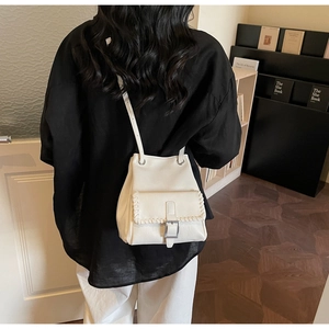 Vue détaillée du sac seau crème montrant les coutures contrastées et la boucle métal