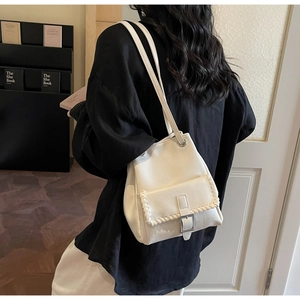 Détail du sac seau en cuir PU blanc avec poche cousue et boucle carrée en métal