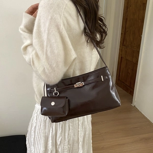 Dettaglio di una borsa hobo marrone scuro lucido con portamonete e fibbie argentate