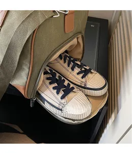 Close-up of green canvas duffel bag showing a functional side compartment for shoes