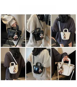 Vues détaillées du mini sac seau montrant les styles porté main et bandoulière avec breloque