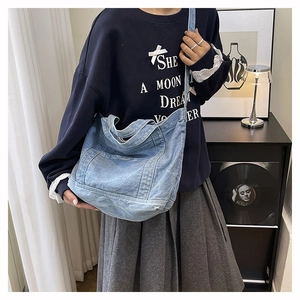Detail of light blue washed denim tote bag showing its soft texture and large capacity
