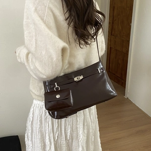 Dettaglio borsa a spalla marrone scuro in pelle lucida vintage con chiusura a scatto in metallo
