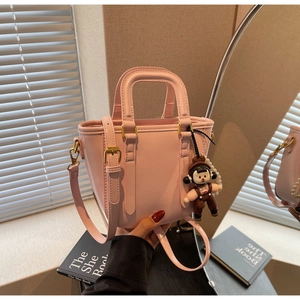 Détail du sac seau rose en cuir PU avec garnitures dorées et breloque dessin animé