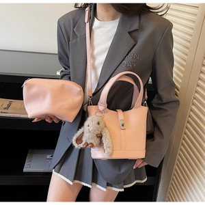 Conjunto de bolso cubo de cuero rosa con colgante de conejo en modelo femenina