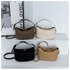 Detailed display of four minimalist moon-shaped leather bags in various elegant neutral colors
