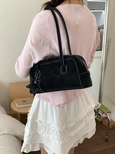 Black minimalist baguette shoulder bag with white stitching and star charm pendant