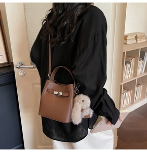 Borsa a secchiello in pelle marrone con chiusura a scatto in metallo e ciondolo a coniglio