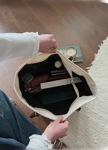 Top view of spacious interior of beige tote bag with brown straps and zipper closure