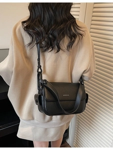 Fashionable black faux leather crossbody bag with flap and decorative side pocket detail