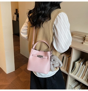 Dettaglio borsa a secchiello in pelle rosa con chiusura argento e ciondolo a coniglio